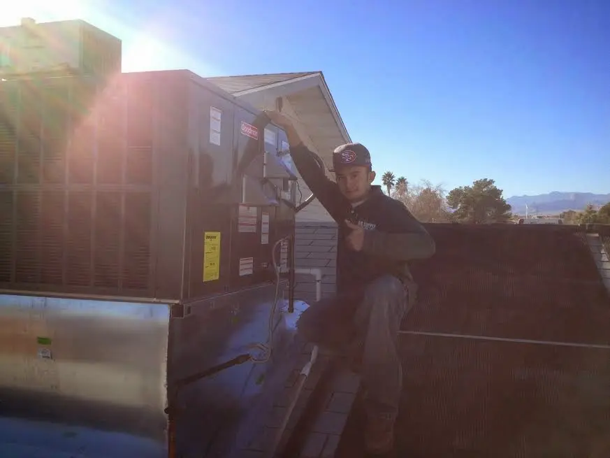 HVAC technician performing AC Tune-Up on a rooftop unit in Holtville